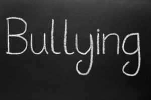 Bullying, written with white chalk on a blackboard.